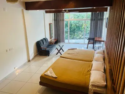 a bedroom with a large bed and a living room at Heaven Hills resorts in Vythiri