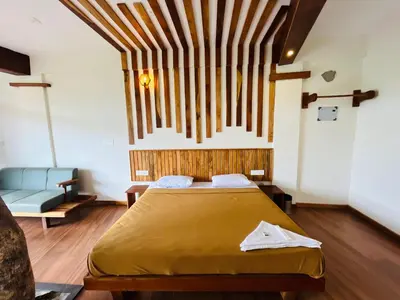 a bedroom with a bed and a couch at Heaven Hills resorts in Vythiri