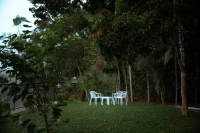 two chairs and a table in a yard with trees at Swasth The Riviera Lovedale in Nilambūr