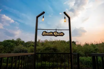 a sign for a monkey restaurant with lights on a fence at Swasth The Riviera Lovedale in Nilambūr