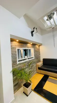 a living room with a couch and a plant at Swasth The Riviera Lovedale in Nilambūr