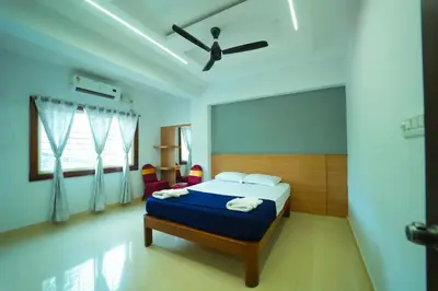 a bedroom with a bed and a ceiling fan at GLN Residency Pure Veg in Kālvādi