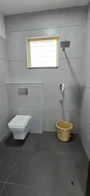 a bathroom with a toilet and a window at GLN Residency Pure Veg in Kālvādi