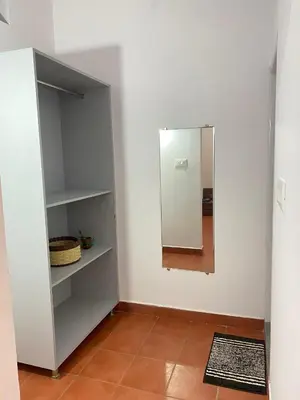 a room with a mirror and a white wall at Aastha homestay in Mysore