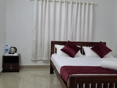 a bedroom with a bed with white and purple pillows at Crystal Riverview Homestay in Kuttampuzha