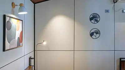 a bathroom with white walls and a light fixture at Cove by Raho - Nestled Away Retreat in Siddapur