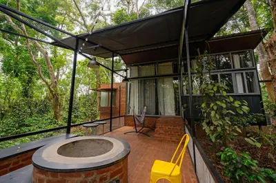 a house with an outdoor hot tub on a patio at Cove by Raho - Nestled Away Retreat in Siddapur