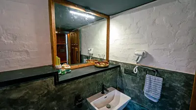 a bathroom with a sink and a mirror at Cove by Raho - Nestled Away Retreat in Siddapur
