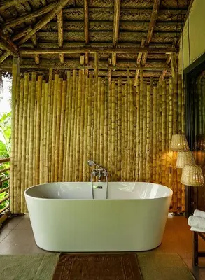 a bath tub in a room with a bamboo wall at The Soul Marayoor Mudhouse - Munnar in Marayoor