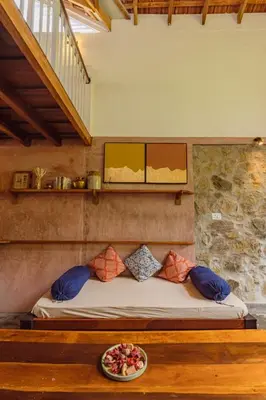a bed in a room with a plate of food on a table at Tool House - Great Estate Stay for Remote Work in Siddapur