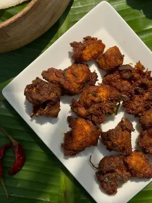 a white plate with fried food on a banana leaf at Tool House - Great Estate Stay for Remote Work in Siddapur