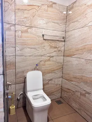 a bathroom with a toilet and wooden walls at Mountain valley in Attappādi