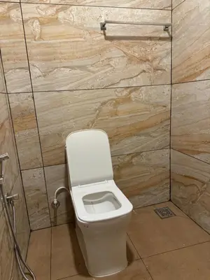 a bathroom with a white toilet in a stall at Mountain valley in Attappādi