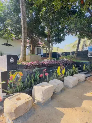 a garden with birds painted on the side of a fence at Mountain valley in Attappādi