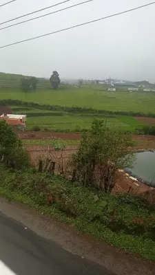 a view of a field with a body of water at Haze cottage- MA Cottage in Ooty
