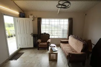 a living room with a couch and two chairs at Haze cottage- MA Cottage in Ooty