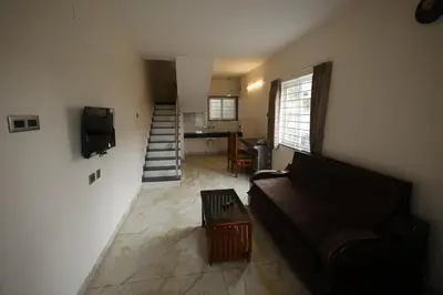 a living room with a couch and a table at Haze cottage- MA Cottage in Ooty