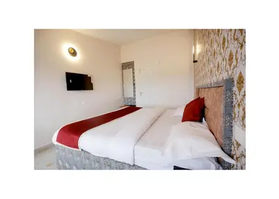 a bedroom with a bed and a tv in it at Haze cottage- MA Cottage in Ooty