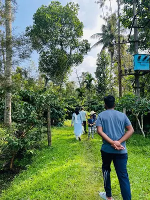 a group of people walking down a path at Preetham Homestay in Kushālnagar