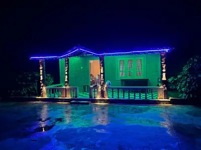 a green house with blue lights on it at night at Preetham Homestay in Kushālnagar