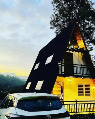 a car parked in front of a yellow house at Hill View 'A'Frame Villa Wayanad in Vythiri