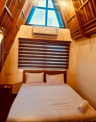 a bedroom with a large bed with a window at Hill View 'A'Frame Villa Wayanad in Vythiri