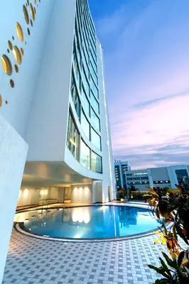 a large building with a swimming pool in front of it at TIARA by MPS in Kozhikode