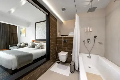 a hotel room with a bed and a bathtub and a bedroom at TIARA by MPS in Kozhikode