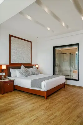 a bedroom with a large bed and a window at TIARA by MPS in Kozhikode