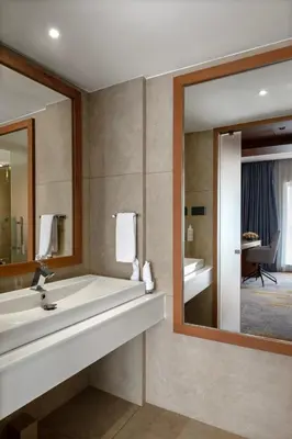 a bathroom with a large mirror and a sink at TIARA by MPS in Kozhikode