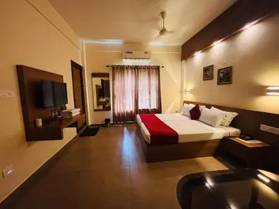 a hotel room with a bed and a sink at Maharani Hotel in Kozhikode