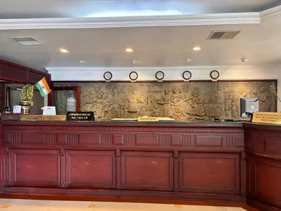 a bar in a restaurant with a stone wall at Maharani Hotel in Kozhikode