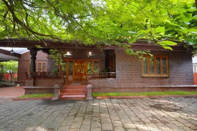 a brick house with a staircase in front of it at Illam Heritage inn Bungalow l 4 BHK in Guruvāyūr