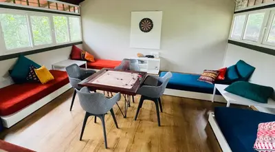 a room with couches and a table and chairs at The Hive at Druv Dakshin Farm Resort in Padinjarathara