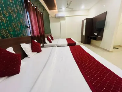 a bedroom with a large white bed with red pillows at My Rooms Channapatna in Channapatna