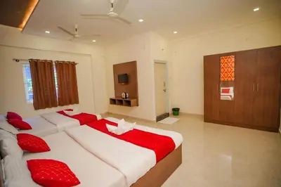 a bedroom with two beds with red pillows at My Rooms Channapatna in Channapatna