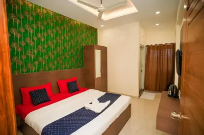 a bedroom with a bed with red pillows and a green wall at My Rooms Channapatna in Channapatna