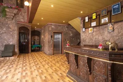 a bar in a room with a stone wall at Devi Enterprises - Hotel Khems in Ooty