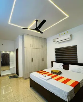 a bedroom with a large bed with a ceiling fan at Diamond Villa Near Rajagiri Hospital in Alwaye