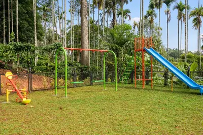 a park with a playground with a slide at Theyila Wayanad Premium Pool Resort in Sultan Bathery