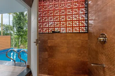 a bathroom with a shower with a glass door at Theyila Wayanad Premium Pool Resort in Sultan Bathery