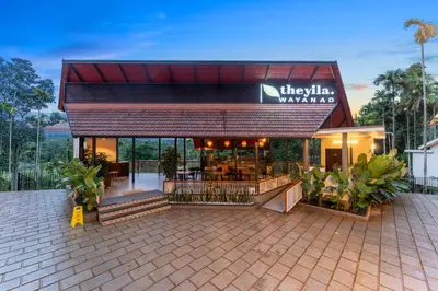 a building with a restaurant in front of it at Theyila Wayanad Premium Pool Resort in Sultan Bathery