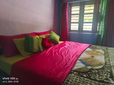 a bed with a pink blanket on top of it at Munnar home stay in Munnar