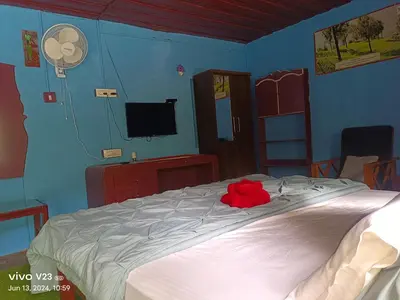 a bedroom with a bed with a red stuffed animal on it at Munnar home stay in Munnar