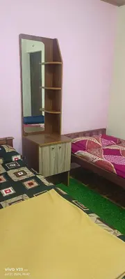 a bedroom with a mirror and a bed and a bed sidx sidx sidx at Munnar home stay in Munnar