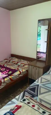 a bedroom with two beds and a mirror in it at Munnar home stay in Munnar