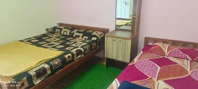 a bedroom with two beds and a mirror at Munnar home stay in Munnar