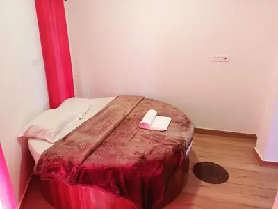a small bed in a room with a red blanket at Valley homes in Ooty