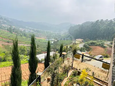 a view of a hill with trees and a road at Valley homes in Ooty