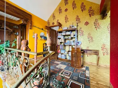 a room with a yellow wall with a room with a shelf at Valley homes in Ooty